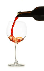 Red wine pouring in glass, isolated on white