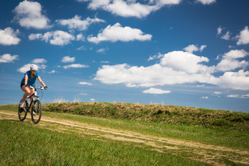 Pretty, young female biker outdoors on her mountain bike 