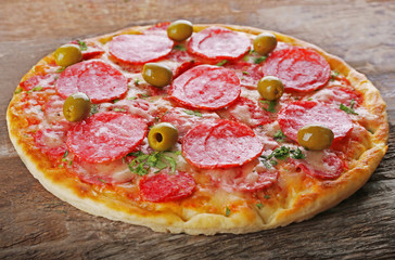 Delicious tasty pizza on wooden background