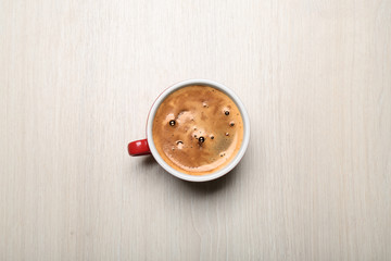 Cup of coffee on light background, top view