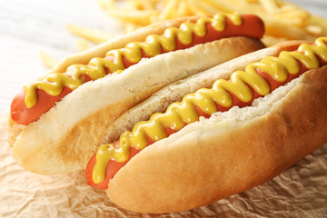 Hot dogs and fried potatoes on wooden background