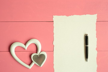 White heart with a note to write on a wooden background pink