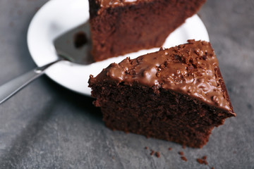 Delicious slice of chocolate cake with nut cream on white plate against grey background, close up