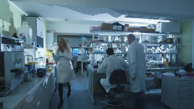 Timelapse footage of a team of scientists in white coats that are working in a modern laboratory. Shot on RED Cinema Camera.