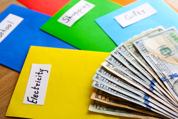 Colourful envelopes with money for needs on wooden background