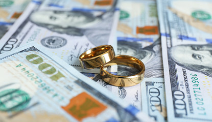 Wedding rings on money background, close up