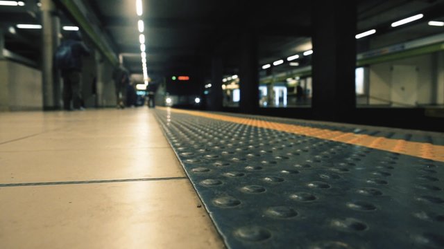 Underground train arriving at a modern station and defocused passengers