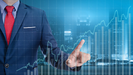 business man touch visual graph on screen with night city backgr