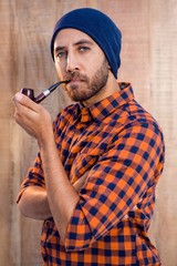 Portrait on confident businessman holding smoking pipe