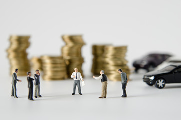 miniature businessman team training with gold coins stack and ca