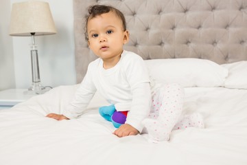 Fototapeta premium Cute baby sitting on bed