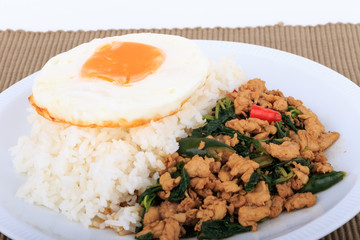 Rice topped with stir-fried chicken, basil and fried egg, fried stir basil with minced chicken on white background (Isolated Background)