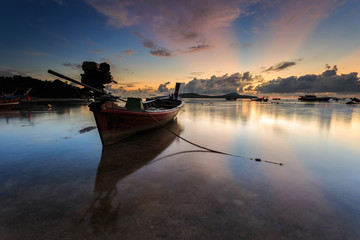 Traditional Thai longtail boat at sunrise beach