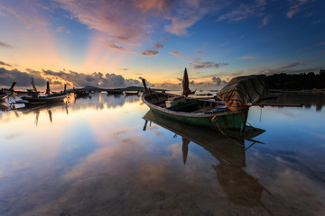 Traditional Thai longtail boat at sunrise beach