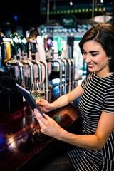 Woman using tablet and having a glass of wine