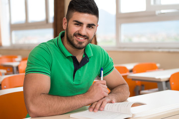 Arabic Student With Books Sitting In Classroom