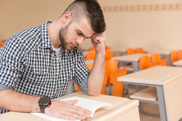 Student With Books Sitting In Classroom