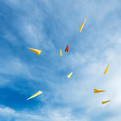 yellow and orange aircraft rocket paper hand made floating in the blue sky.
