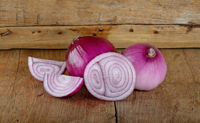 Red onion on the wooden background