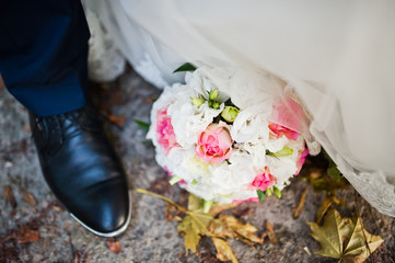 Wedding bouquet near leg of groom