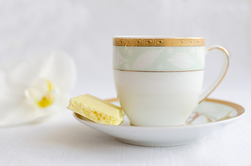Tasty white porous chocolate and cup of coffee