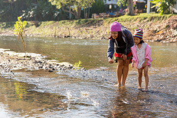 Mother and daughter playing in river