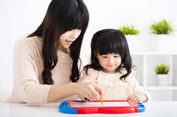 Mother or teacher helping child daughter to writing