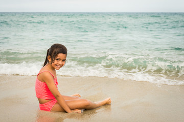 Fototapeta na wymiar little girl playing with a starfish on the beach