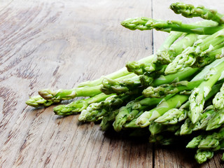 green raw asparagus on wooden table background