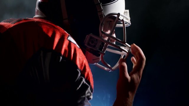American football sportsman player corrects a helmet