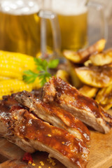 BBQ Ribs on a platter with beer in the background