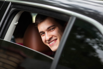 stylish confident young groom waits bride in the car