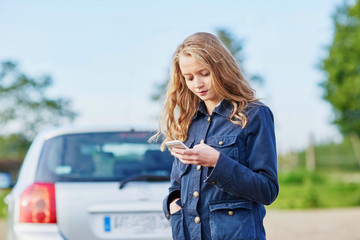 Woman on the road near a broken car calling for help