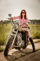 Obraz na płótnie Canvas Biker girl sitting on motorcycle