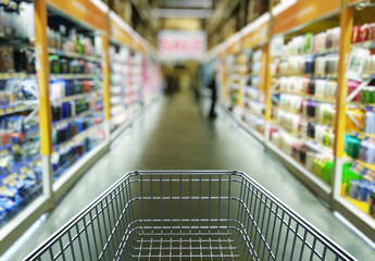 Empty shopping cart in supermarket store interior - retail and shopping concept