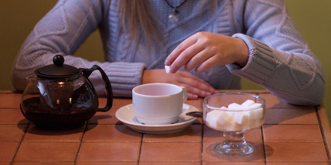 View of woman, putting sugar in the teacup