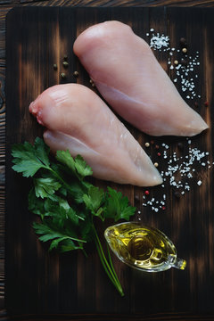 Top view of raw chicken breast fillets with seasonings, close-up