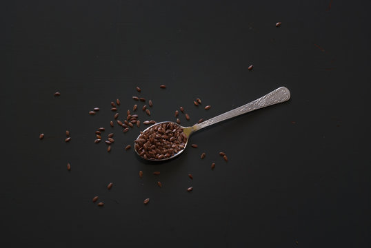 Linseed On Metal Spoon On Dark Wooden Table