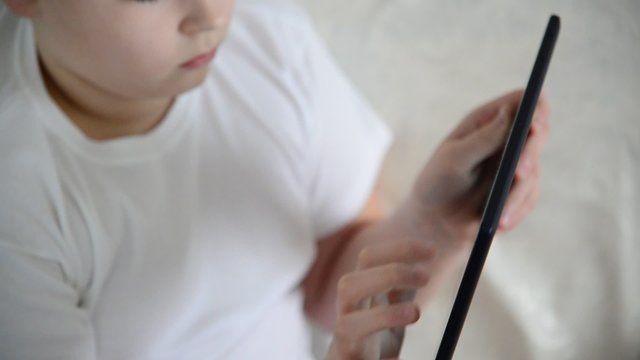Teen boy enjoys  tablet indoors