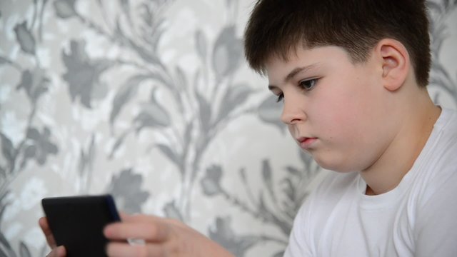 Teen boy enjoys  tablet indoors
