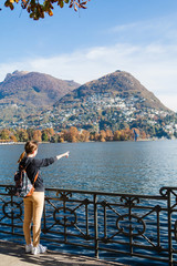 Young girl looking and pointing at the panoramic scenery. Lugano