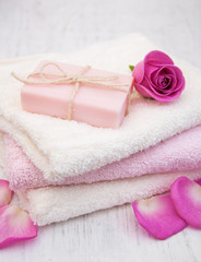 Fototapeta na wymiar Bath towels and soap with pink roses