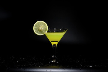 A glass of juice is standing on a black table