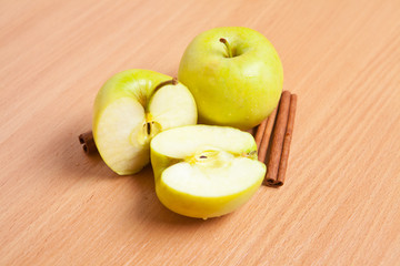cinnamon sticks and apples on a wooden background