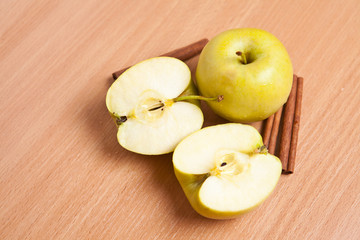 cinnamon sticks and apples on a wooden background