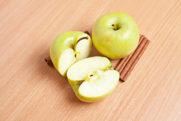cinnamon sticks and apples on a wooden background