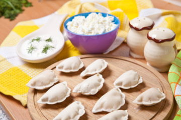 raw dumplings on a cutting board with cheese