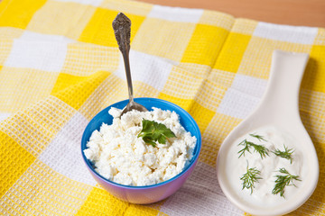 cottage cheese in a bowl with a metal spoon on a checkered yello