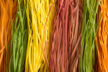 Background of colorful raw pasta. (Beet, carrot, paprika, spinach). 