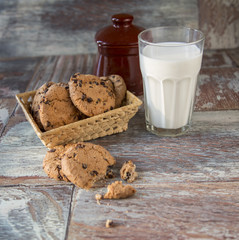 Tasty cookies and glass of milk on rustic wooden background